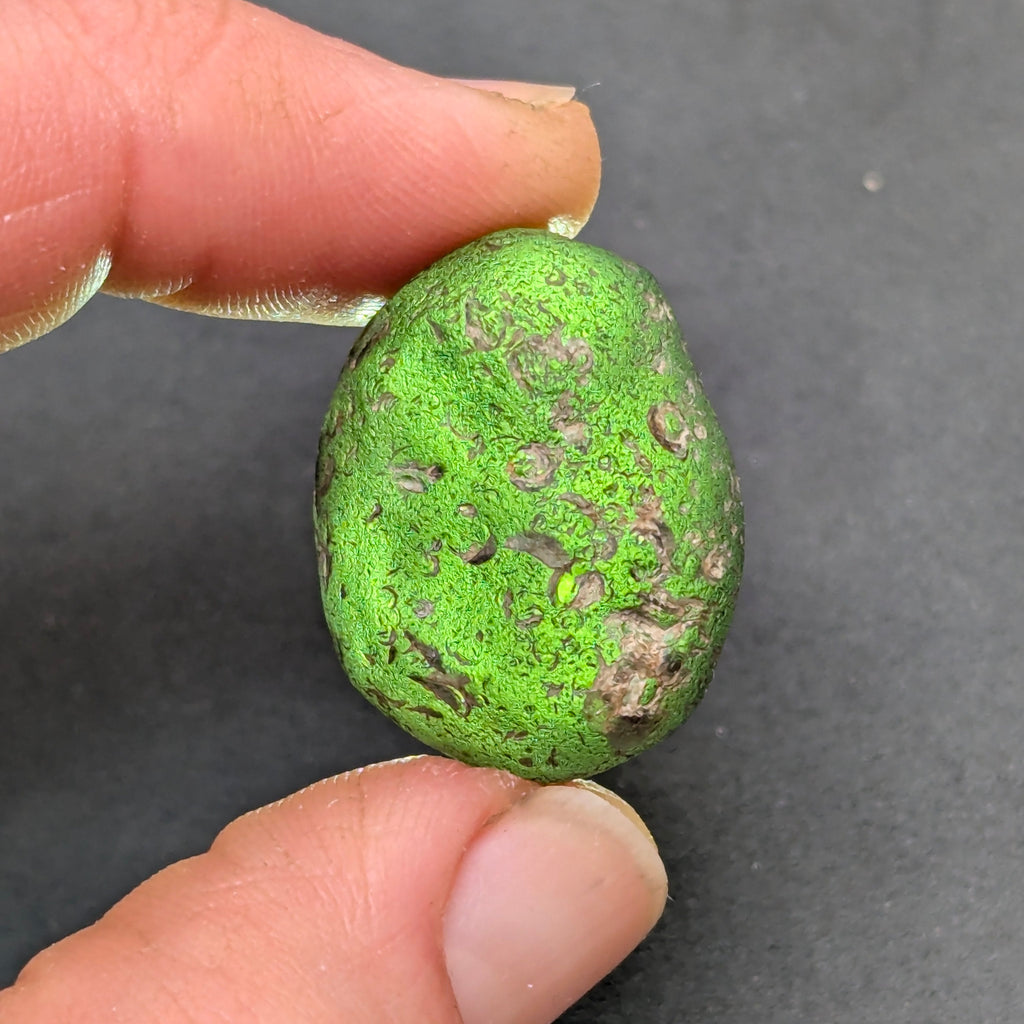 Natural Moldavite from the Zliv locality weighing 7.12 g with rounded oval pebble-like form, naturally worn surface, subtle remaining pits and preserved solid core characteristic of field-found specimens - back side, backlight.