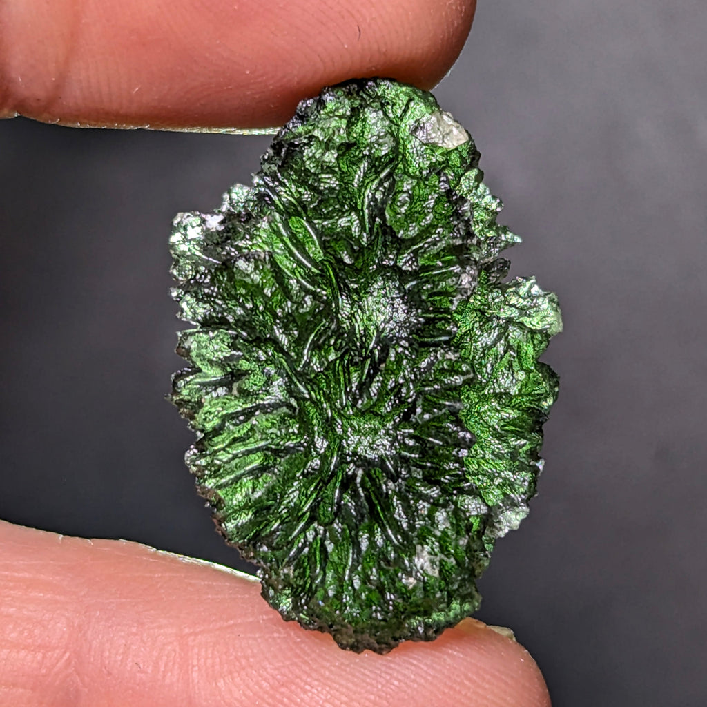 Natural Moldavite from the Olešnice locality weighing 5.67 g with egg-shaped form, deep sharply textured sculpture, rich green translucency and preserved natural surface - back side, backlight.