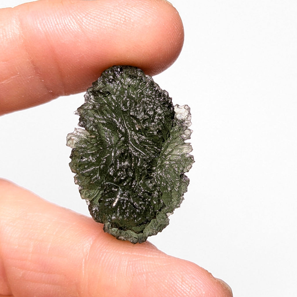 Natural Moldavite from the Olešnice locality weighing 5.67 g with egg-shaped form, deep sharply textured sculpture, rich green translucency and preserved natural surface - front view.
