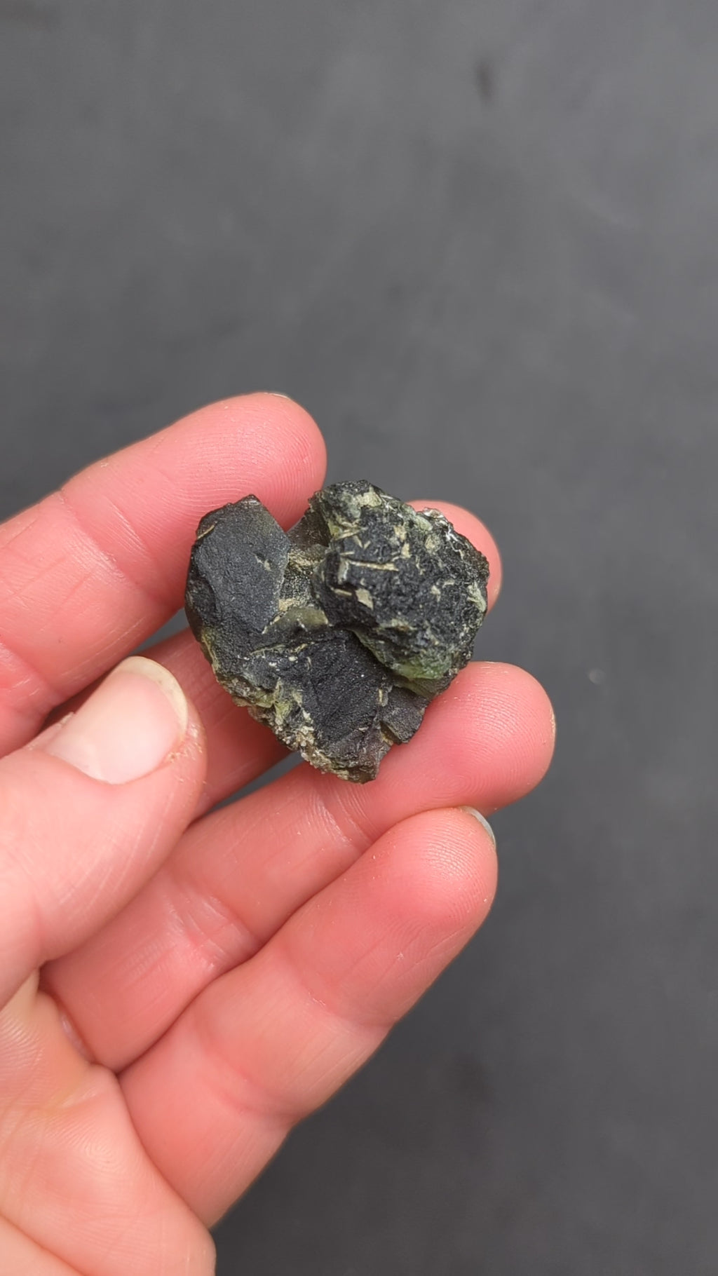 Heart-shaped natural raw moldavite with newly formed sculpture after natural separation, velvety matte surface and fine pyramidal micro-sculpture in hand - video.