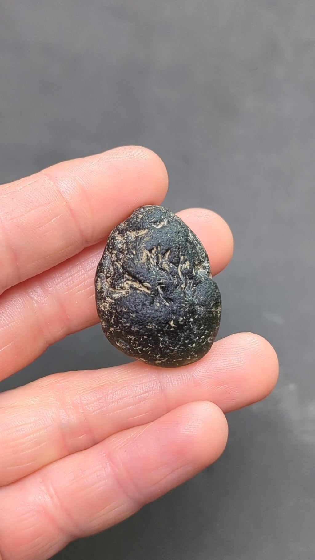 Olive green moldavite 12.5g from Zliv, oval shape with clay residues, video.