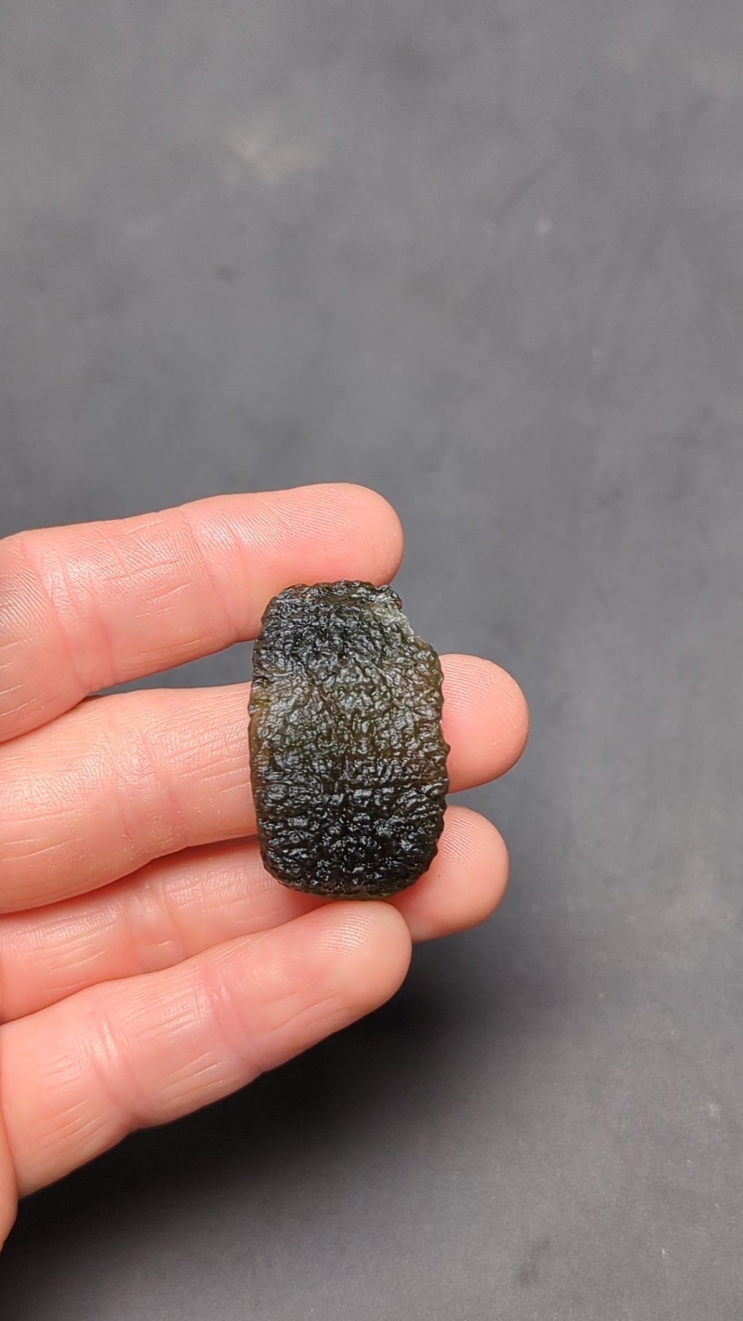 Natural Moldavite from the Olešnice locality weighing 8.86 g with hollow shape, open bubble formation, matte to velvety surface, subtle glossy areas and olive green color in hand - video.