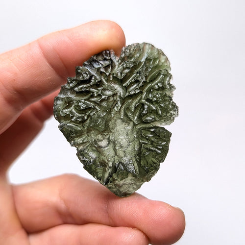 Natural Moldavite from the Besednice Ježkovna locality with pronounced hedgehog-like sculpture, deep radial relief and richly textured surface on white background - front view.