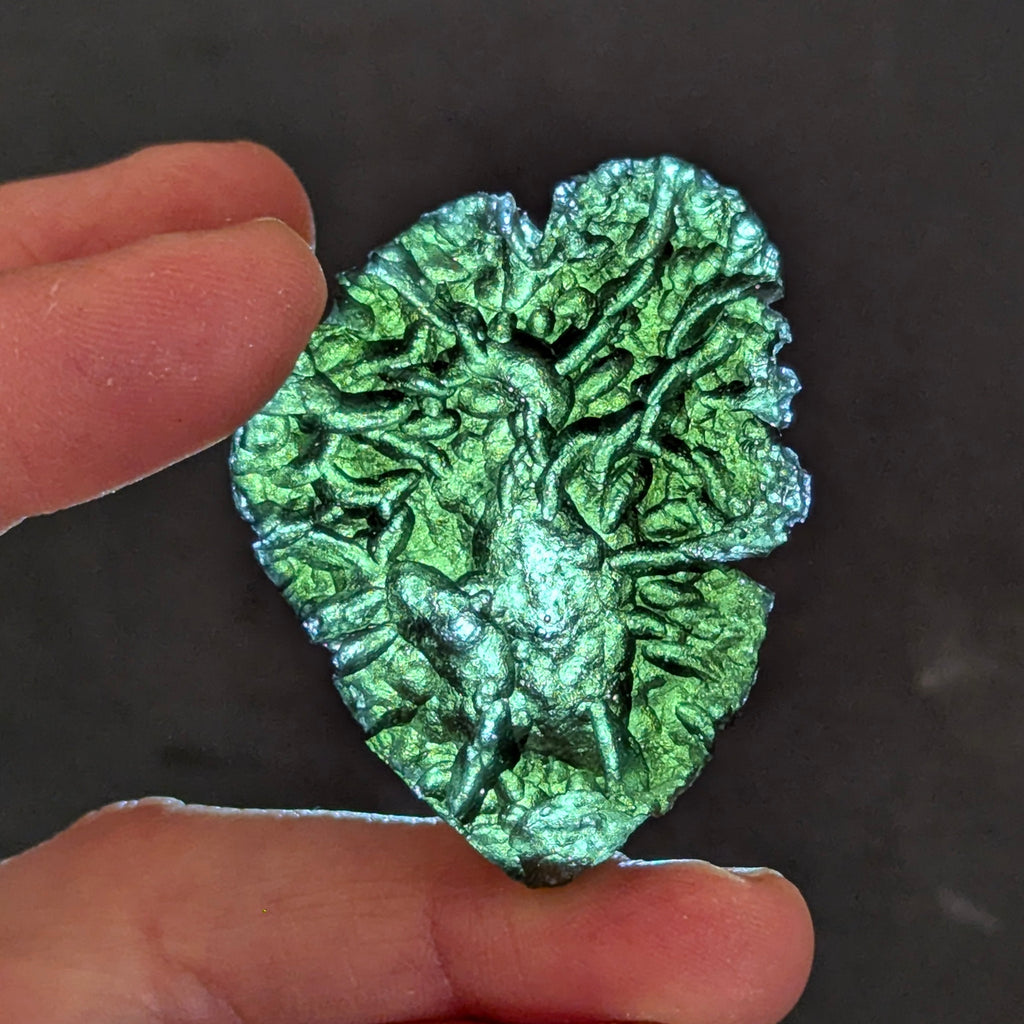 Natural Moldavite from the Besednice Ježkovna locality with pronounced hedgehog-like sculpture, deep radial relief and richly textured surface on white background - front view, backlight.