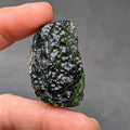Natural Moldavite from the Krasejovka locality on white background with glossy lacquer-like surface, deep sculpture, pronounced grooves, vivid green translucency and authentic natural relief. Weight 14 g - front view.