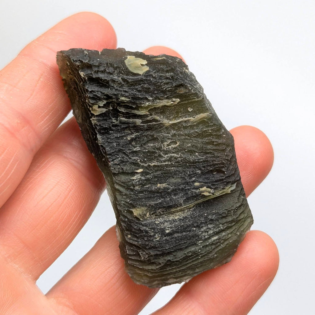 Natural Slavče 25.71 g moldavite with two different sculpting textures and elongated natural shape - white background, back side.