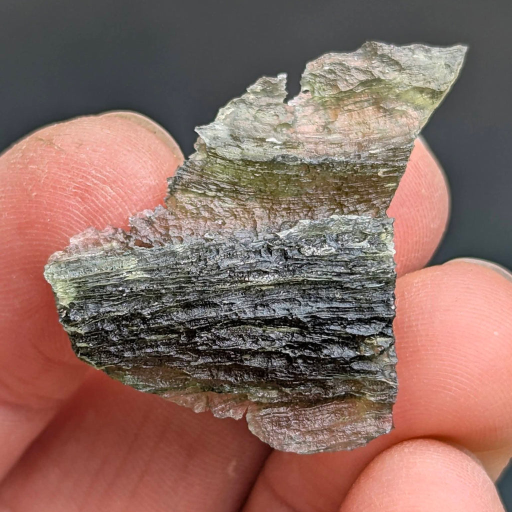Natural Brusná 4.29 g - moldavite with rare layered sculpture, olive-green translucent glass and distinctive textured surface, back side.