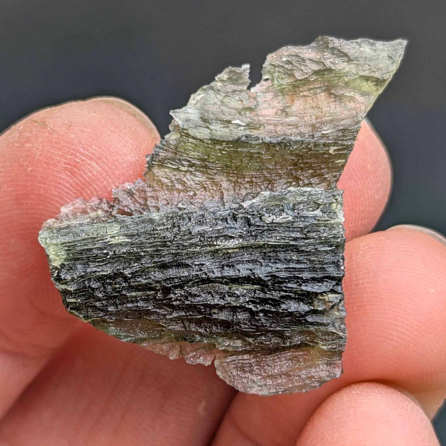 Natural Brusná 4.29 g - moldavite with rare layered sculpture, olive-green translucent glass and distinctive textured surface, back side.