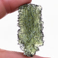 Natural Moldavite from the Dobrovská Lhotka – Bažina locality with rich sculpture, serrated edges, saturated olive green color and pronounced surface texture in hand - back side, natural transluency.