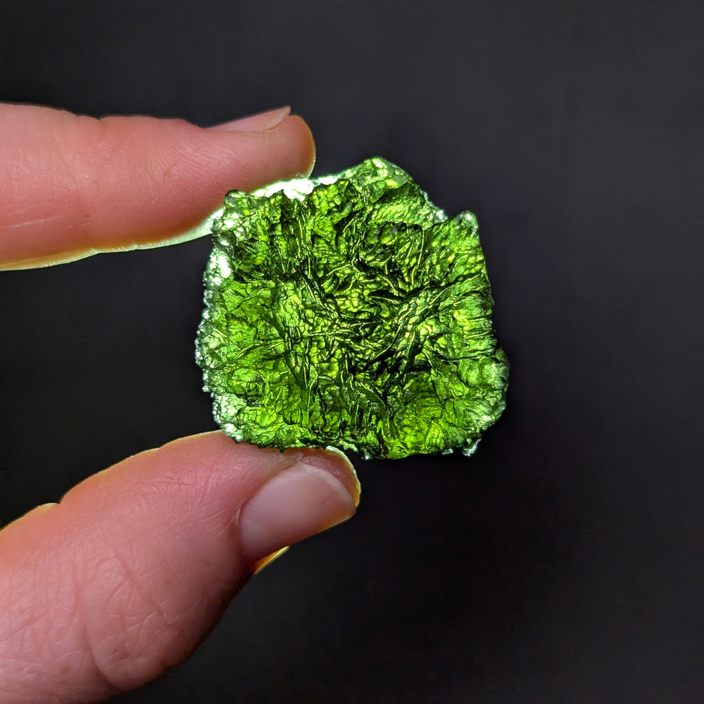 Natural Olešnice 13.87 g moldavite with deep sculpted texture and vivid green translucency under transmitted light - backlight.