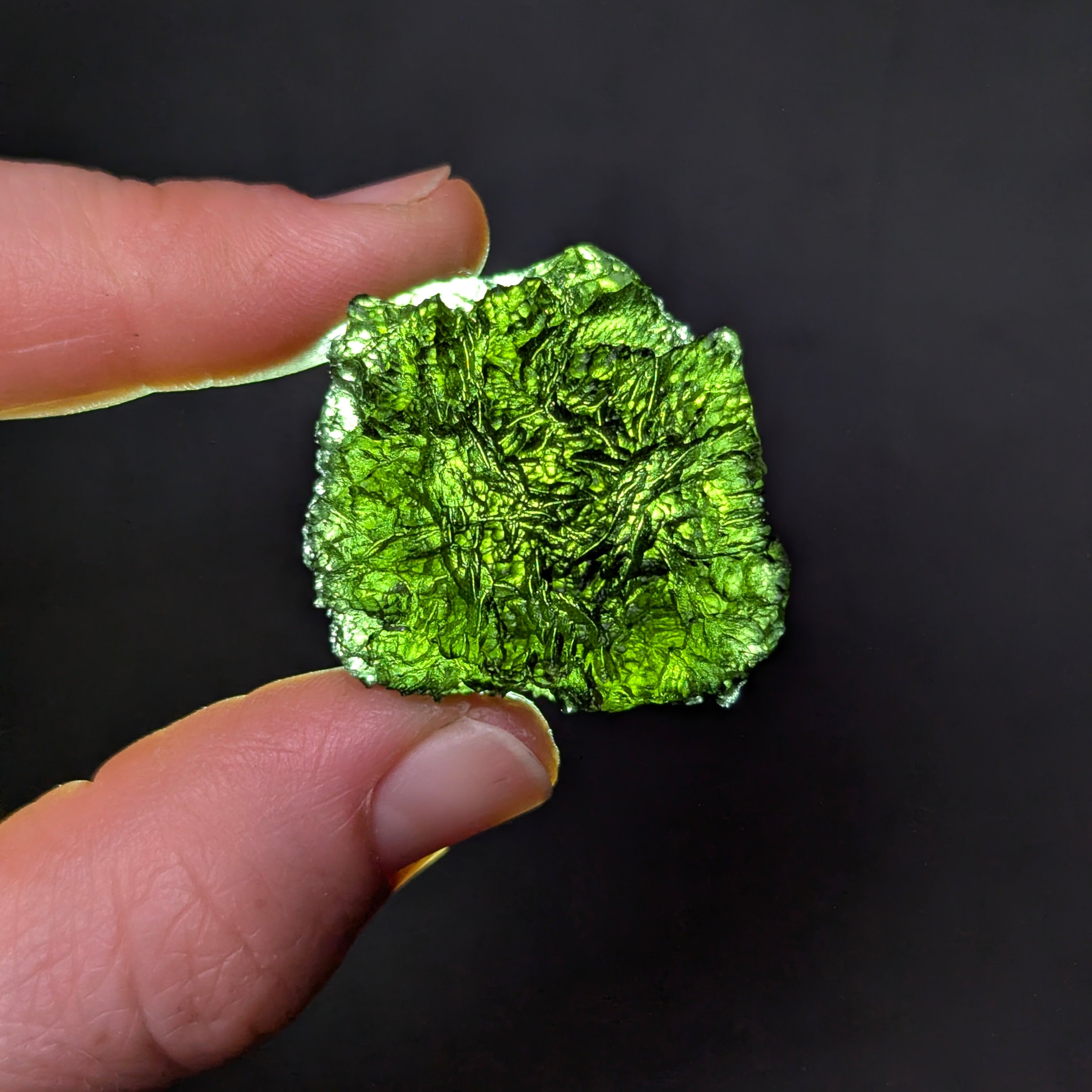 Natural Olešnice 13.87 g moldavite with deep sculpted texture and vivid green translucency under transmitted light - backlight.