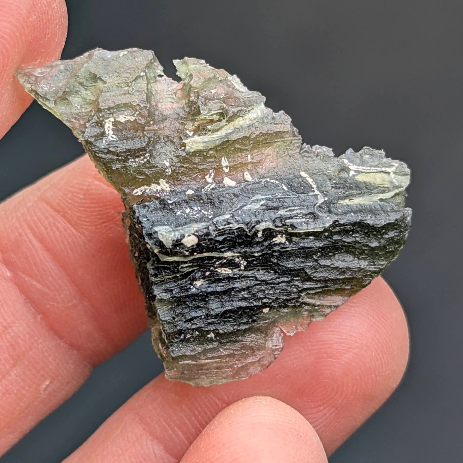 Natural Brusná 4.29 g - moldavite with rare layered sculpture, olive-green translucent glass and distinctive textured surface, front view.