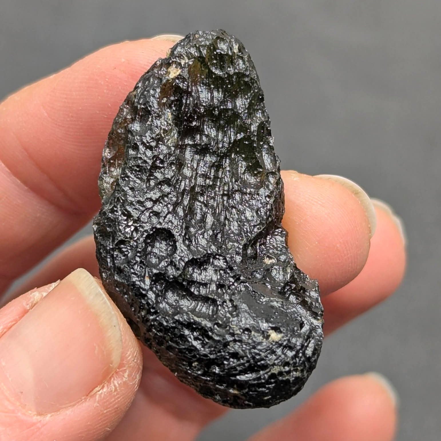 Natural Moldavite from the Něchov locality with deep plastic sculpture, pronounced grooves, dark olive green translucency and authentic natural relief. Weight 8.57 g - back side.