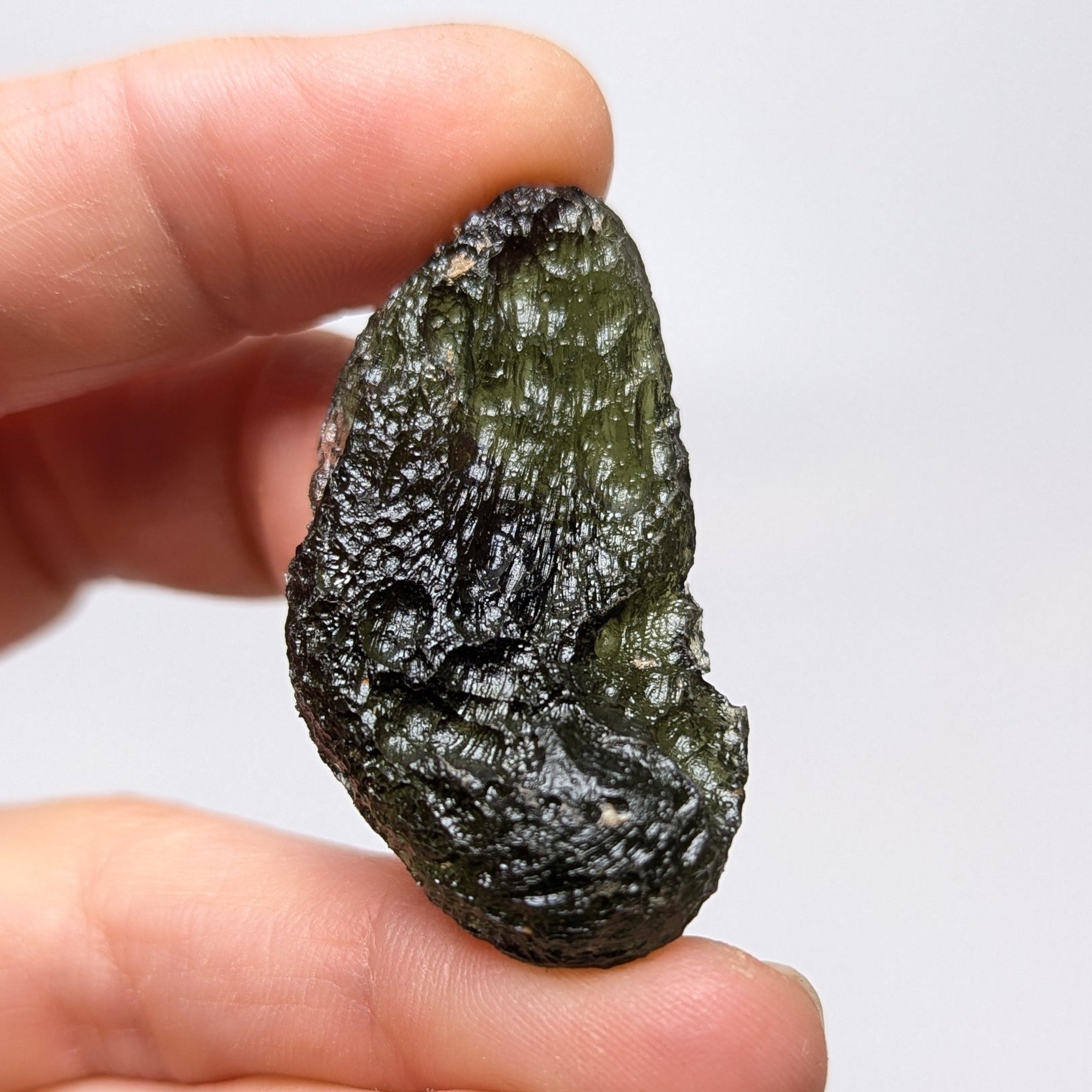 Natural Moldavite from the Něchov locality on white background with deep plastic sculpture, pronounced grooves, dark olive green translucency and authentic natural relief. Weight 8.57 g - back side.